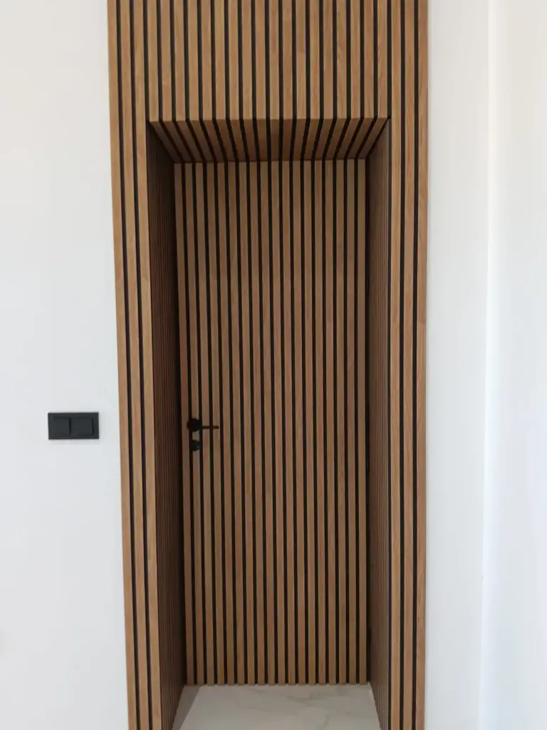 Detalle de la puerta de madera de listones de la tienda de AOVE Pagos de Aherca en Valdepeñas