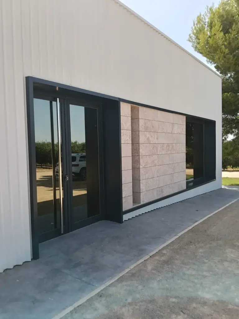 Entrada acristalada a la sala de catas de Pagos de Aherca para visitas de oleoturismo en Valdepeñas